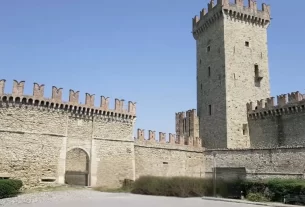 Castelo medieval em excelente estado de conservação, localizado na região da Emilia-Romagna, na Itália, sob um céu azul.