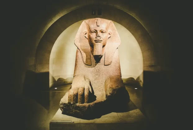 A majestosa Esfinge de Tanis, exposta no Museu do Louvre em Paris, é uma das joias da coleção egípcia do museu. Esta estátua de granito, datada do Reino Novo (cerca de 1200 a.C.), exsuda poder e mistério, com seu corpo de leão e rosto humano adornado por uma coroa dupla. Localizada na seção de antiguidades egípcias, ela atrai visitantes que buscam explorar a rica história do Antigo Egito. Uma visita a esta peça impressionante é um convite para viajar no tempo e apreciar a grandiosidade da civilização faraônica. Dica de viagem: Explore a área ao redor da Esfinge para descobrir outras relíquias egípcias e planeje sua visita durante a manhã para uma experiência mais calma.